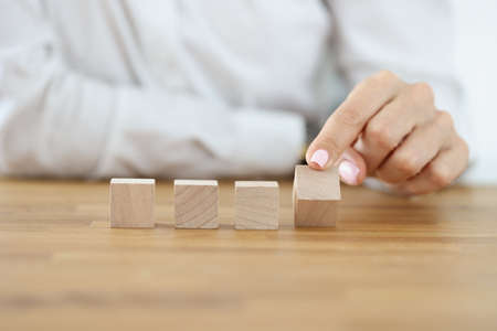 Business woman flipping one wooden cube from rowの写真素材