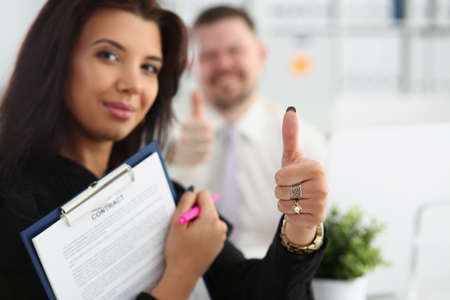 Beautiful woman holds a contract and shows ok gestureの写真素材