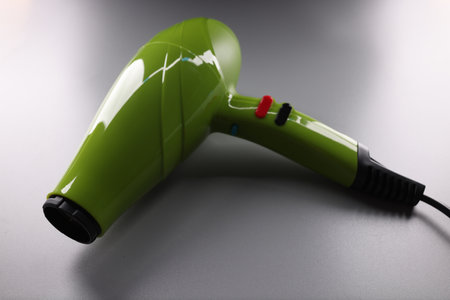 Green professional hair dryer lying on gray background closeupの写真素材