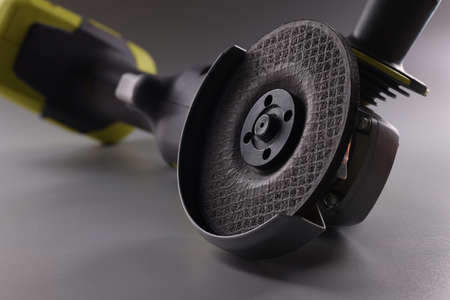 Angle pneumatic grinders grinder with a disc on a gray backgroundの写真素材