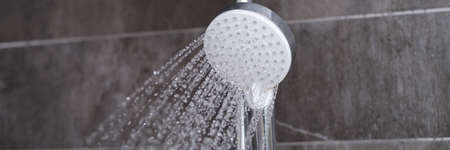 Cheap tap is pouring rain in the bathroom closeupの写真素材