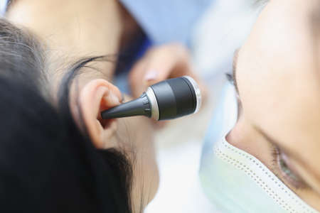 Doctor check patient on medical examination with special ear equipmentの写真素材