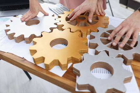 Businessmen are stacking gold and silver gearsの写真素材