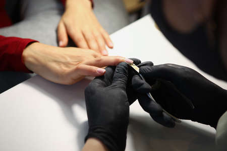 Nail master cutting off cuticle on clients hands with special equipmentの写真素材