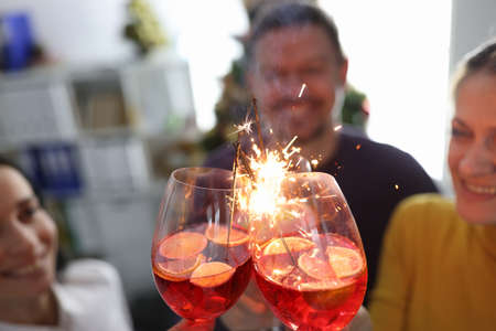 Friends celebrating at party with cocktails and sparklers