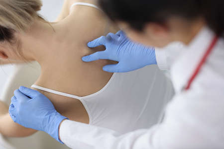 Chiropractor doctor presses on a womans spine