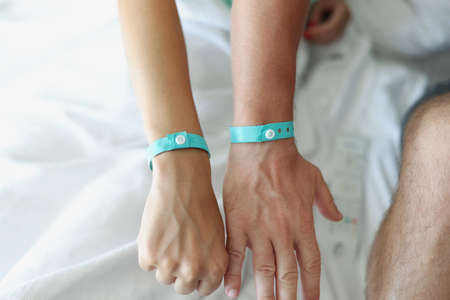 On the male and female hands a blue hotel braceletの写真素材