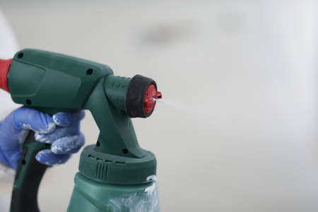 Spray gun in the hands of a builder, close-upの写真素材