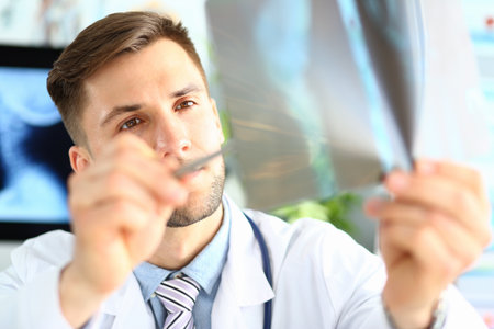 Male doctor examining x-ray in clinic closeupの写真素材