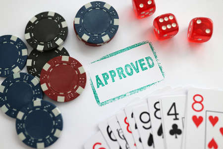 Stamp approved standing near playing cards and chips in casino with dice closeup