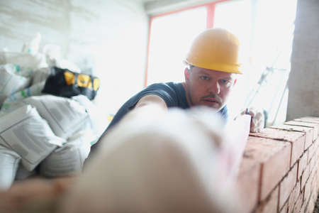 Concentrated male builder measure distance with level equipmentの写真素材