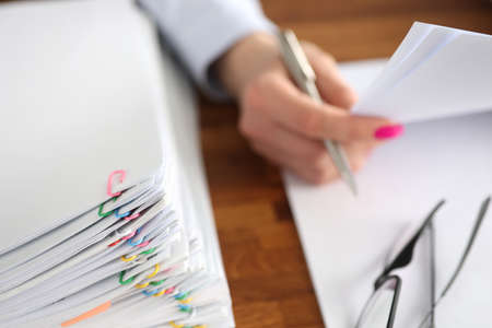 Woman secretary working with papers at her desk closeup