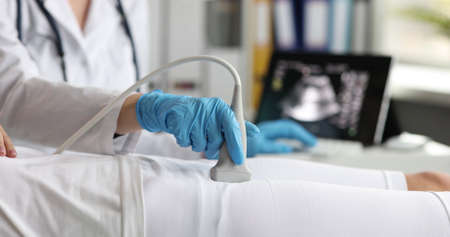 Pregnant woman makes obstetric sonogram ultrasound equipment in hospital closeup