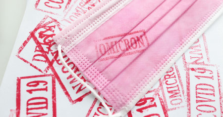 Pink medical mask with omicron stamp closeup