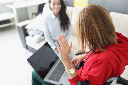 Young disabled woman with laptop on her lap