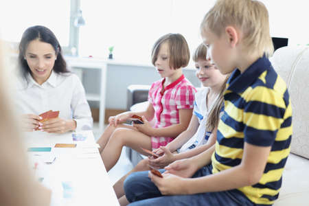 Children hold playing cards, game with parents at home, games for development