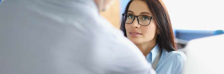 Beautiful woman in the office looks at the man