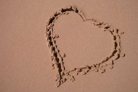 Heart is painted on sand of sea beach closeup