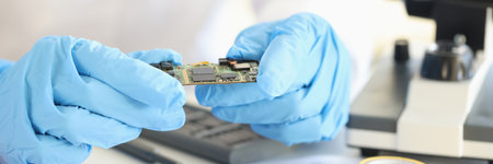 Scientists holding microchip in rubber gloves in laboratory closeupの写真素材