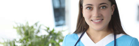 Portrait of smiling female doctor with stethoscope in medical clinicの写真素材