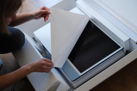 Woman hands unpacking box with modern personal computerの写真素材