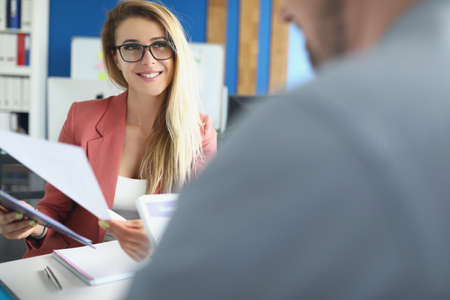 Optimistic woman discuss business papers with colleague, lady bossの写真素材