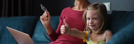 Mom and daughter pay by card for purchases