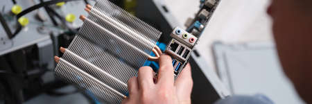 Male repairman holding motherboard, hands close-up