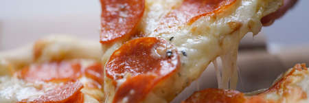 A man takes a large slice of hot neopoletan pizza