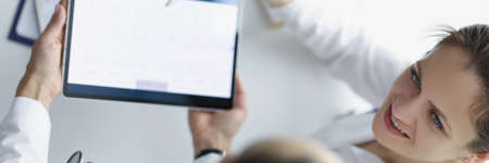 Top view of practitioners discussing patients cardiogram and treatmentの写真素材