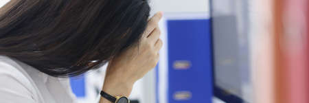 Exhausted woman in office workspaceの写真素材