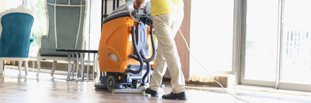Male cleaner cleaning interior of modern hotel lobbyの写真素材
