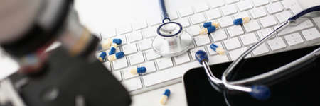 On the keyboard are capsules and a stethoscope