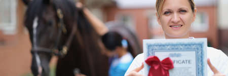 Woman doctor shows horse veterinary certificateの写真素材