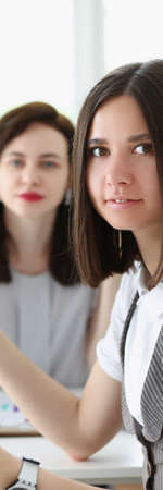 Business women working on monthly report surrounded with bunch of papersの写真素材