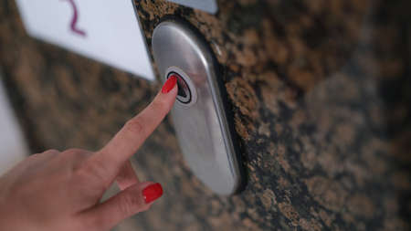 Female finger with presses elevator button closeup