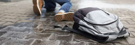 Man get up from ground after falling on slippery asphalt in winterの写真素材
