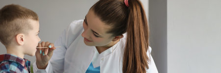 Doctor collects biological material from boy saliva, swab test for kidsの写真素材