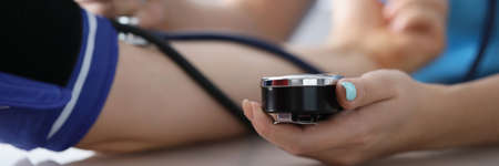 Doctor measuring patients blood pressure with tonometer tool on planned appointment