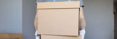 Helper carry heavy cardboard boxes with owners belongings to new house