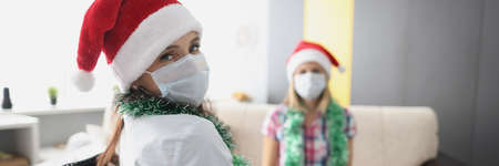 Young woman visit friend in hospital, relative in wheelchair, face mask for protectionの写真素材