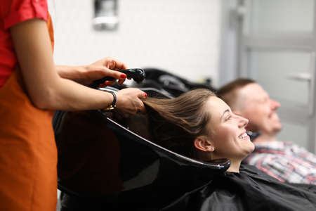 Beautiful happy smiling woman, professional hairdresser washes hairの写真素材