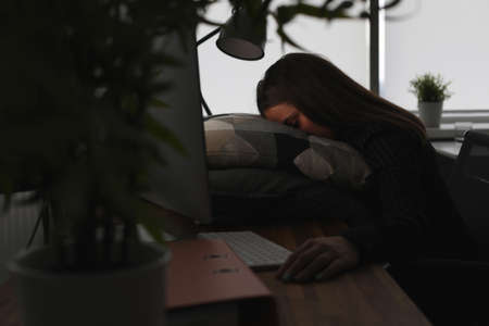 Freelance woman exhausted by hard work is sleeping in officeの写真素材