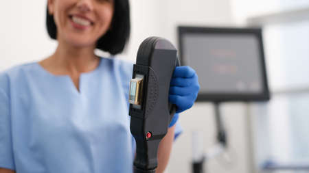 Woman beautician sets up laser hair removalの写真素材
