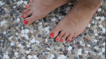 Woman bare feet stand on stone tile floorの写真素材