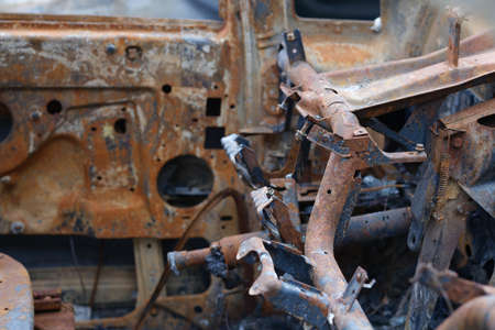 Burnt rusty abandoned car in parking lotの写真素材