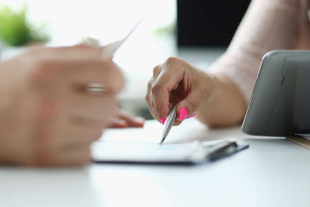 Business people write and discuss documents with tablet computer on tableの写真素材