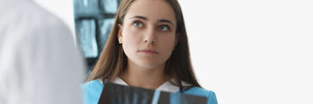 Woman doctor communicating with colleague with xrays in clinicの写真素材