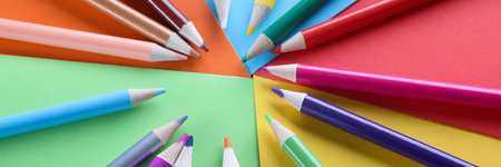 Lot of sharp wooden pencils lying on multicolored background closeupの写真素材