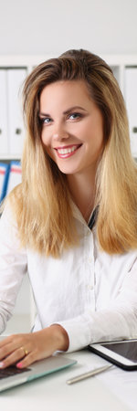 Cheerful young office worker sit on working place, search information onlineの写真素材